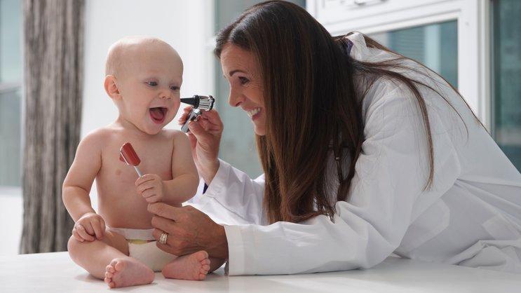Fröhliches Baby mit Kinderärztin
