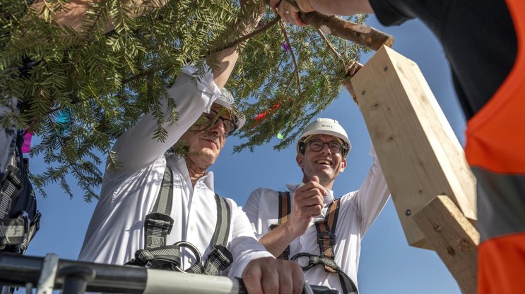 Gut gesichert setzen Sicherheitsdirektor Mario Fehr und GVZ-Direktor Lars Mülli die Richttanne aus dem Korb einer Autodrehleiter.