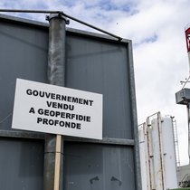 En Suisse, la géothermie a du mal à s'imposer: Une pancarte devant le chantier lors d'une manifestation contre le projet de geothermie profonde a Haute-Sorne en mai 2024 a Glovelier.