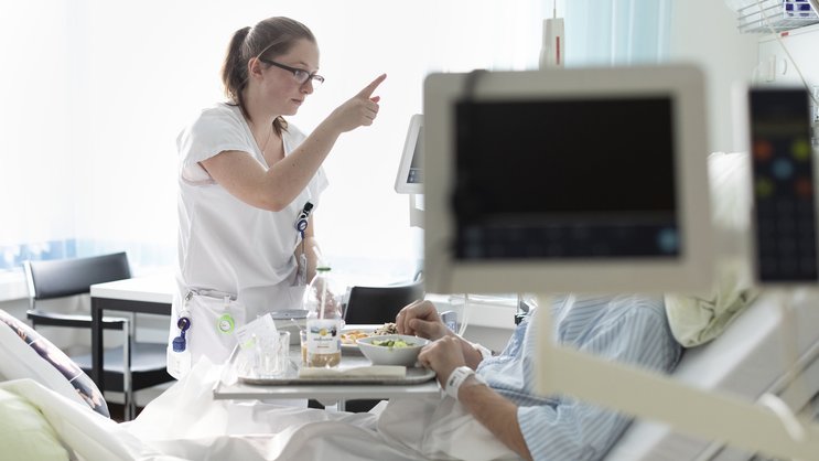 Une infirmière s'occupe d'un patient dans le service de neurochirurgie de l'Inselspital à Berne.