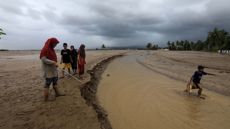 Une zone ouverte recouverte de boue et d'eau dans un village touché par les inondations dans la région de Meureudu, à Pidie Jaya, Aceh, en Indonésie.
