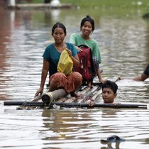 Des victimes d'inondations pataugent dans les eaux avec un radeau de fortune lors des inondations à Taungoo, division de Bago, Myanmar, en septembre 2024. Les fortes pluies déclenchées par le typhon Yagi ont provoqué de graves inondations dans certaines régions du Myanmar.
