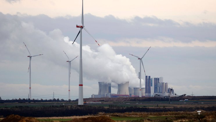 Kohlekraftwerk und Windpark: Auch Versicherer sind von fossilen Energien abhängig.