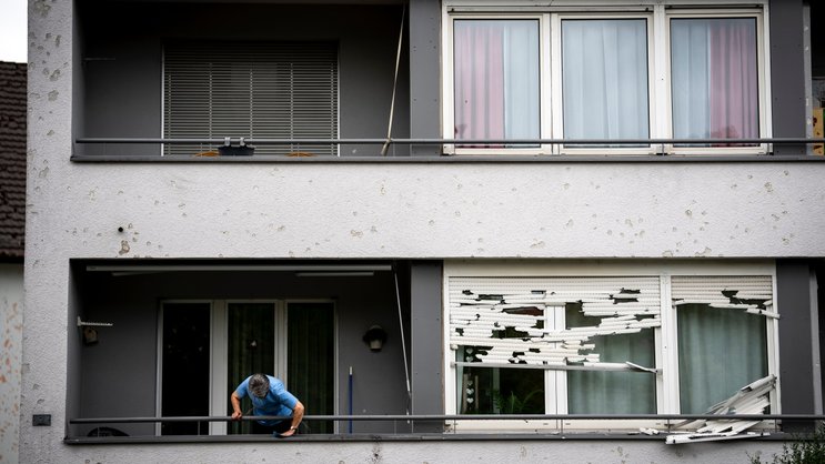 Des volets roulants détruits et des éléments de façade endommagés sur un immeuble résidentiel à Bülach (ZH) après la tempête de grêle de vendredi matin.